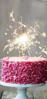 Pink cake with sparklers on a stand.