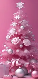 Pink Christmas tree with silver ornaments and gifts in elegant holiday style.