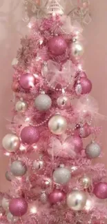 Whimsical pink Christmas tree with decorations.