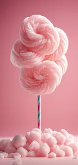 Pink cotton candy on a stick with a pastel background.