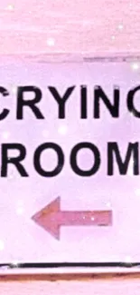 Pink wall with a crying room sign and arrow.