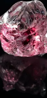 Pink crystal on a reflective black surface wallpaper.