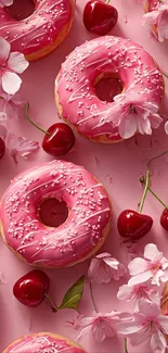 Pink donuts with cherries and blossoms on a pink background.