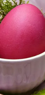 Pink Easter egg nestled in a cup.