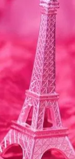 Miniature pink Eiffel Tower on a vibrant background.