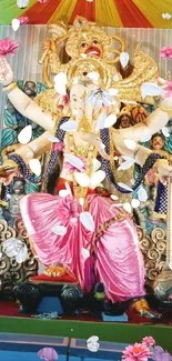 Hindu deity statue with ornate details and falling petals.