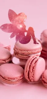 Pink fairy with galaxy wings sitting on pink macarons.