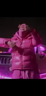 Person in pink jacket with a car in neon pink lights.