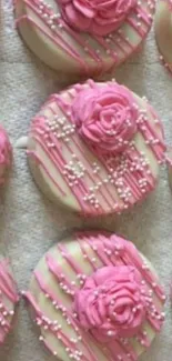 Pink floral cookies with rose designs and pearl sprinkles on a textured background.