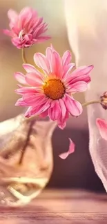 Pink flower in glass vase wallpaper on mobile.