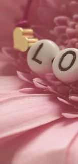 Pink flower with 'LOVE' beads in focus.