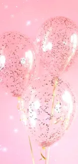 Three pink glitter balloons on a pink background.