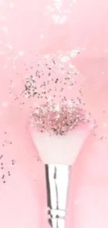 Pink glitter-covered makeup brush on a soft pink background.