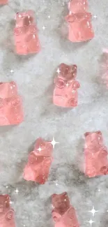 Mobile phone wallpaper with pink gummy bears on a marble background.