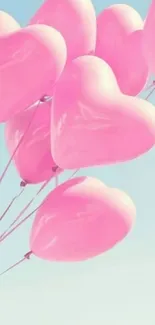 Pink heart-shaped balloons against a blue sky.