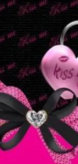 Pink heart mobile wallpaper with 'Kiss Me' design and black bow.