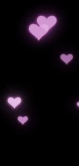 Mobile wallpaper with glowing pink hearts on a black background.