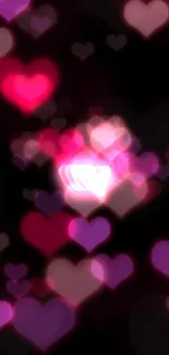 Pink neon heart with glow effect on black background wallpaper.