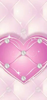 Pink heart with pearl accents on a soft patterned background.