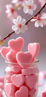 Jar of pink heart-shaped candies with cherry blossoms.