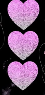 Pink glitter hearts on black background wallpaper with elegant design.