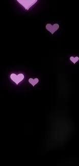 Mobile wallpaper with pink hearts on black background.