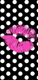 Vibrant pink lips on black and white polka dots background.