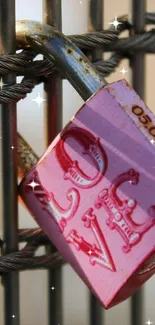 Pink lock attached to a metal wire fence with blurred background.