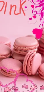 Pink macarons with floral and heart design artfully arranged.