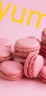 Pink macarons with 'yum' text on a vibrant background.