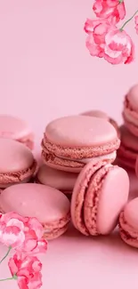 Pink macarons with floral accents on a soft pink background.