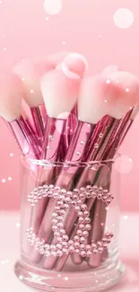 Elegant pink makeup brushes in a stylish glass container.