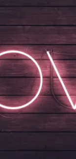 Pink neon lighting spells 'LOVE' on a dark wooden background.