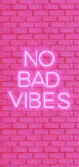 No Bad Vibes neon sign on pink brick wall.