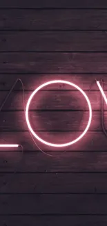 Pink neon text on dark wood background with modern feel.