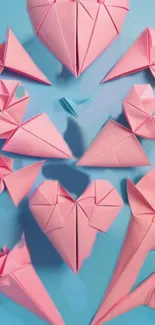 Pink origami hearts on a blue background with creative patterns.