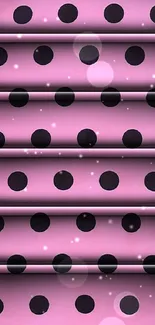 Pink wallpaper with bold black polka dots creating a stylish pattern.