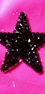 Glossy black star on bright pink fabric background wallpaper.