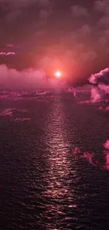 Pink sunset over ocean with clouds.