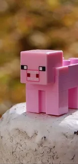 Pixelated pink pig on a stump with autumn foliage.