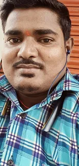 Person in blue plaid shirt with headphones on.