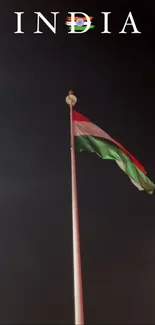 Indian flag waving against a dark sky at night.