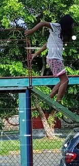 Child climbing on colorful playground with green trees in the background.