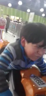 Child enjoying an arcade game ride with a playful expression.