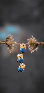 Animated characters hang playfully on a rope with a blurred background.