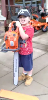 Child in red shirt holding a toy chainsaw with orange hues.