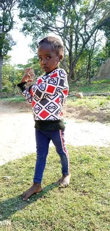 Child enjoying a sunny day in nature, surrounded by greenery.