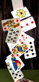 Falling playing cards on a dark wooden background.