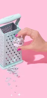 Hand with disco ball and grater on pink background.