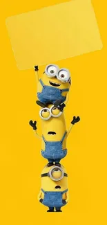 Stack of playful minions on yellow background.